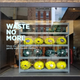 A store window with the text "Waste No More"